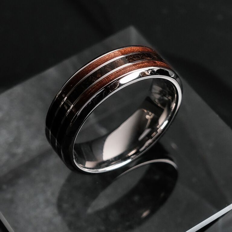 "Cartesian Ring", ein stilvoller Ring aus Walnuss und Silber mit einem modernen, eleganten Design auf einer reflektierenden Oberfläche.